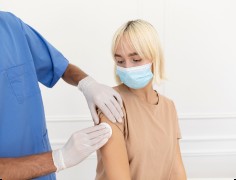 Eine Frau mit Mundschutz nach einer Impfung